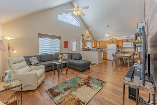 living room with ceiling fan, light wood-type flooring, and high vaulted ceiling