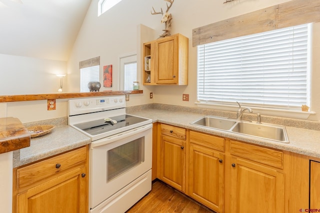 kitchen featuring kitchen peninsula, light wood-type flooring, vaulted ceiling, sink, and white range with electric cooktop