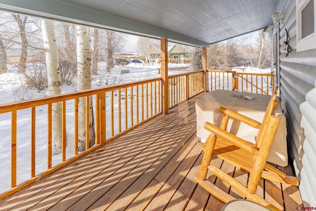 snow covered deck with a porch