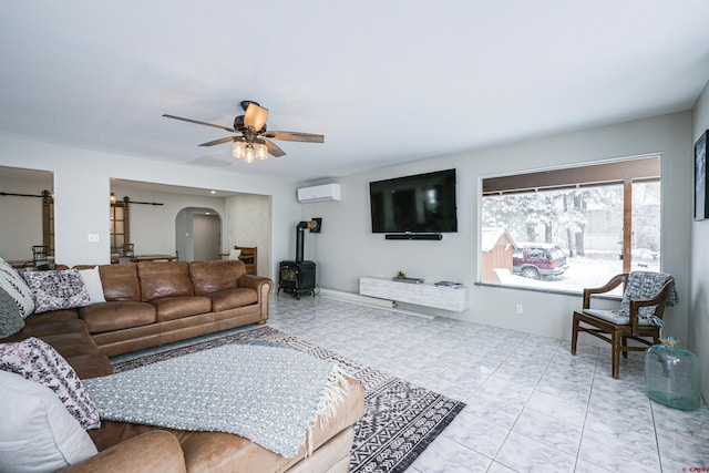 living room featuring a wood stove, ceiling fan, and a wall unit AC