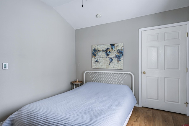 bedroom with dark hardwood / wood-style floors and vaulted ceiling