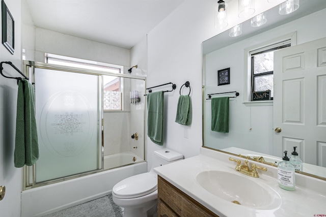 full bathroom featuring vanity, enclosed tub / shower combo, and toilet