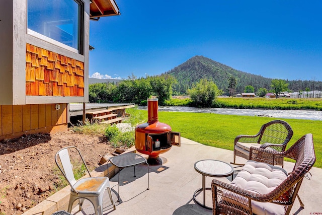 view of patio featuring a water and mountain view