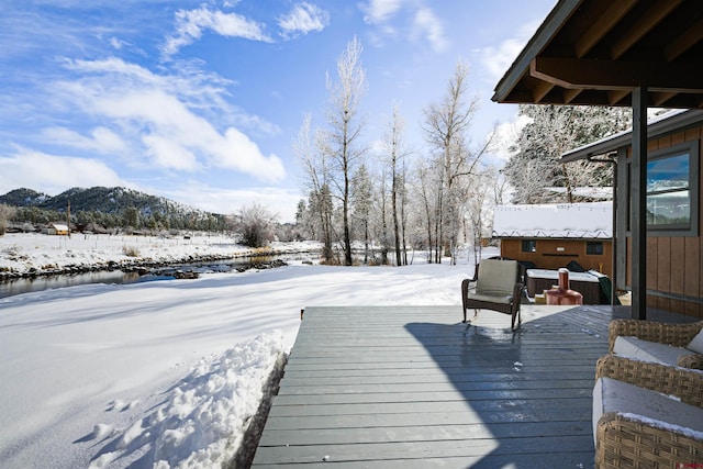 snow covered deck with a mountain view