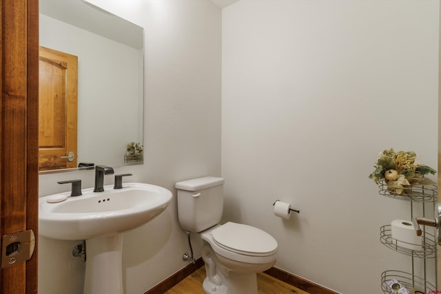 bathroom featuring sink, wood-type flooring, and toilet