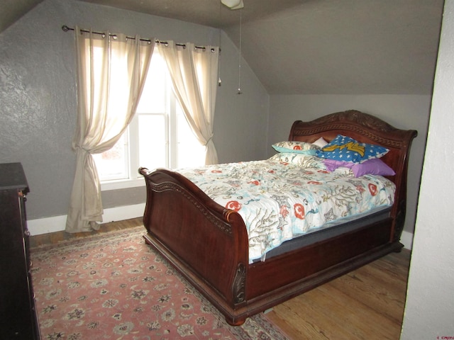 bedroom featuring vaulted ceiling and light hardwood / wood-style flooring