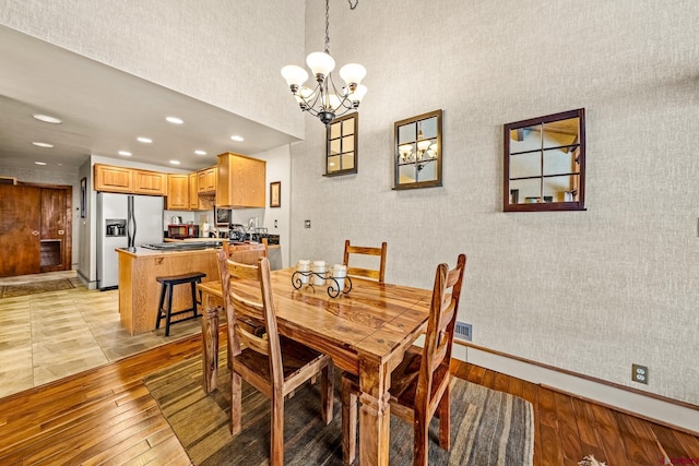 dining area featuring light hardwood / wood-style floors and a notable chandelier