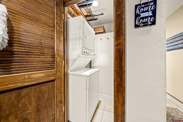 washroom featuring stacked washer and dryer and light tile patterned flooring