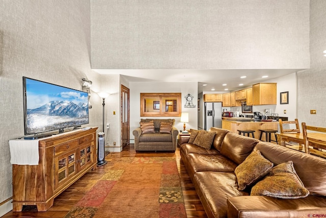 living room with light hardwood / wood-style flooring and a towering ceiling