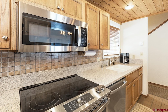 kitchen with sink, tasteful backsplash, light tile patterned flooring, wood ceiling, and stainless steel appliances