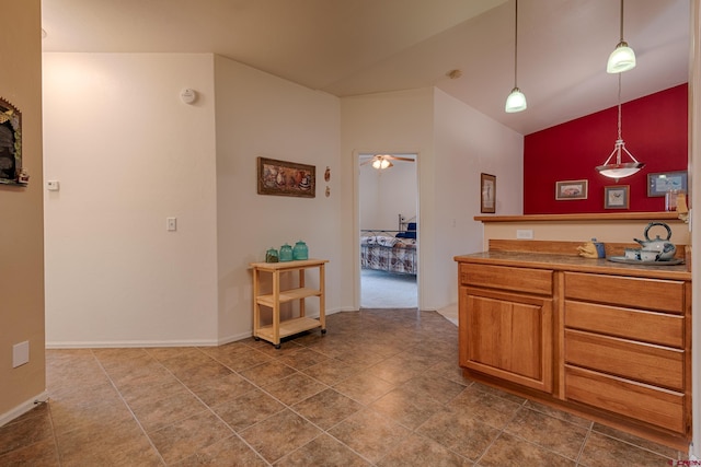 kitchen featuring ceiling fan, lofted ceiling, and hanging light fixtures