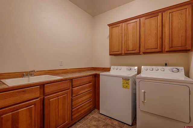 laundry area featuring tile patterned floors, cabinets, separate washer and dryer, and sink