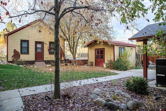 bungalow-style house featuring an outbuilding and a front lawn