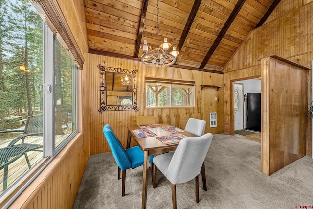 carpeted dining room with lofted ceiling with beams, plenty of natural light, wooden ceiling, and wooden walls