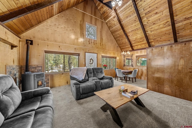 carpeted living room featuring beamed ceiling, wooden walls, a wood stove, and wood ceiling