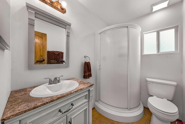 bathroom featuring tile patterned floors, vanity, a shower with shower door, and toilet