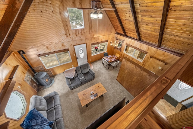 carpeted living room with high vaulted ceiling, wooden walls, ceiling fan, beamed ceiling, and wood ceiling