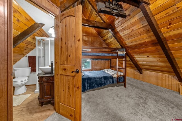 bedroom with vaulted ceiling with beams, connected bathroom, and wooden ceiling