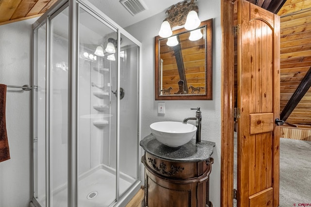 bathroom with vanity, a shower with shower door, and wood ceiling