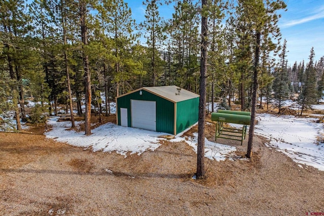 snow covered structure featuring a garage