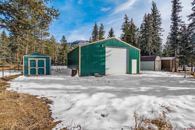 snow covered structure featuring a garage