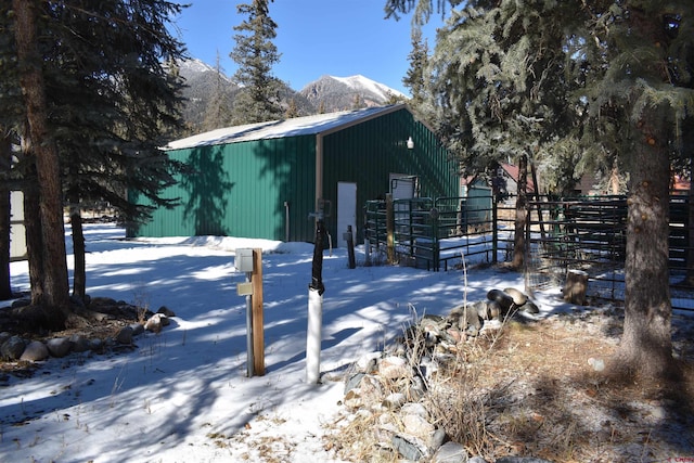 view of snow covered exterior with a mountain view and an outdoor structure