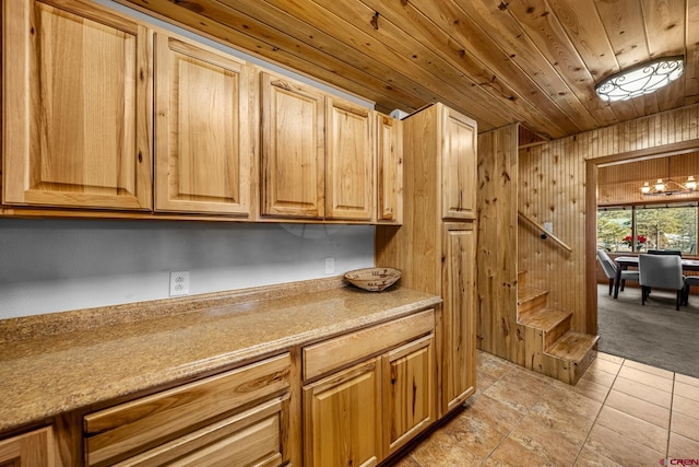 kitchen with wood walls, light tile patterned floors, and wood ceiling