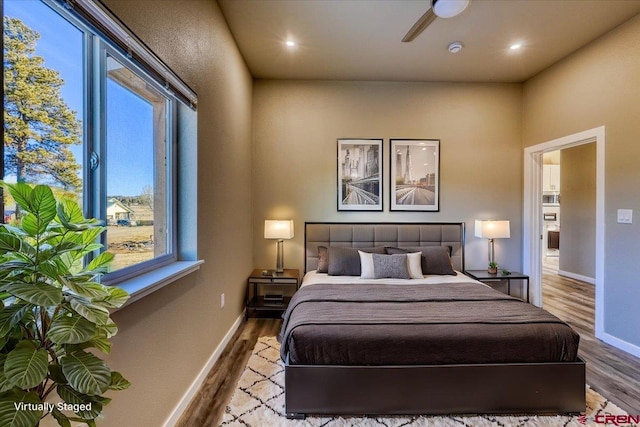 bedroom featuring ceiling fan, wood-type flooring, and multiple windows