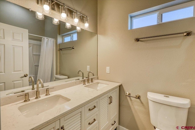 bathroom with a shower with curtain, vanity, toilet, and a healthy amount of sunlight