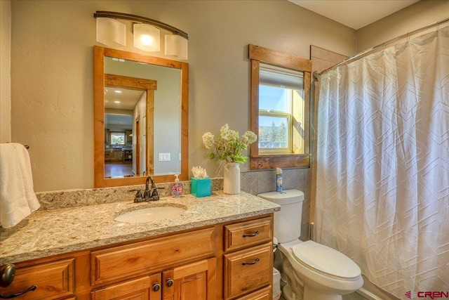 bathroom with a shower with shower curtain, vanity, and toilet