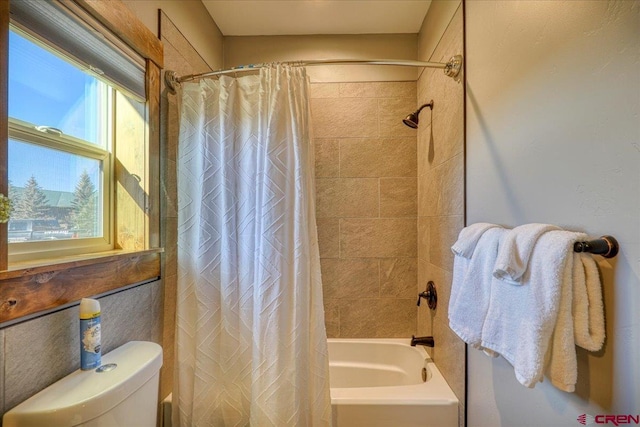 bathroom featuring toilet and shower / bathtub combination with curtain