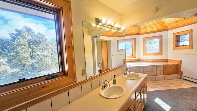 bathroom with baseboard heating, vanity, a relaxing tiled tub, and toilet