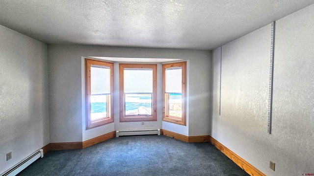 empty room featuring carpet flooring, a textured ceiling, and a baseboard heating unit