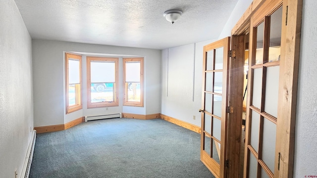 empty room featuring dark colored carpet, french doors, a textured ceiling, and a baseboard heating unit