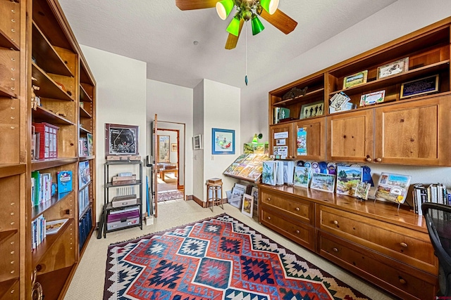 interior space featuring light carpet and ceiling fan