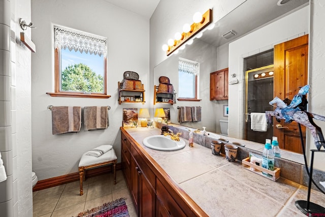 bathroom with vanity, a shower with door, tile patterned flooring, and toilet