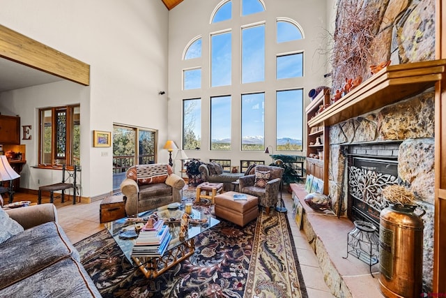 living room featuring a fireplace, a towering ceiling, and light tile patterned flooring