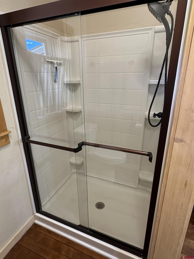 bathroom with hardwood / wood-style floors and an enclosed shower