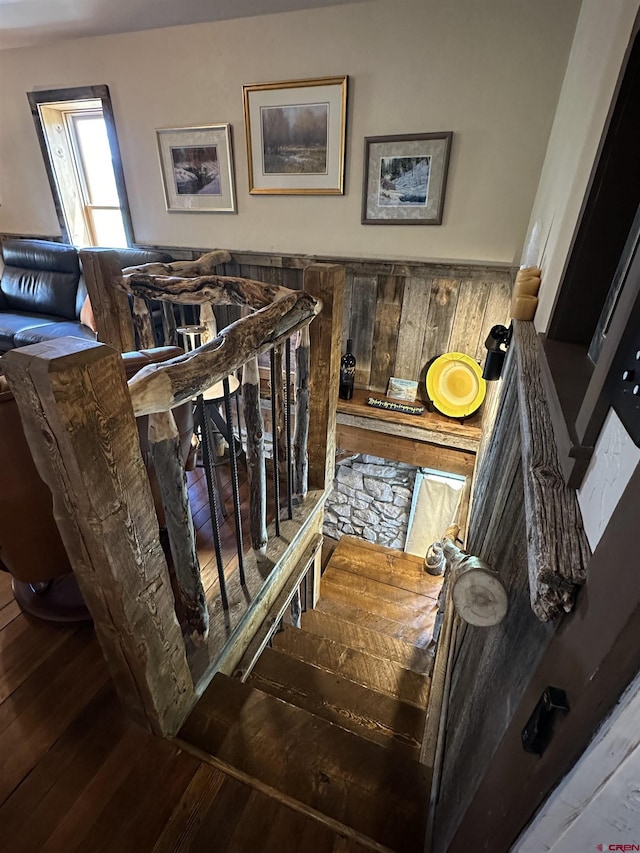 staircase featuring hardwood / wood-style floors and wood walls