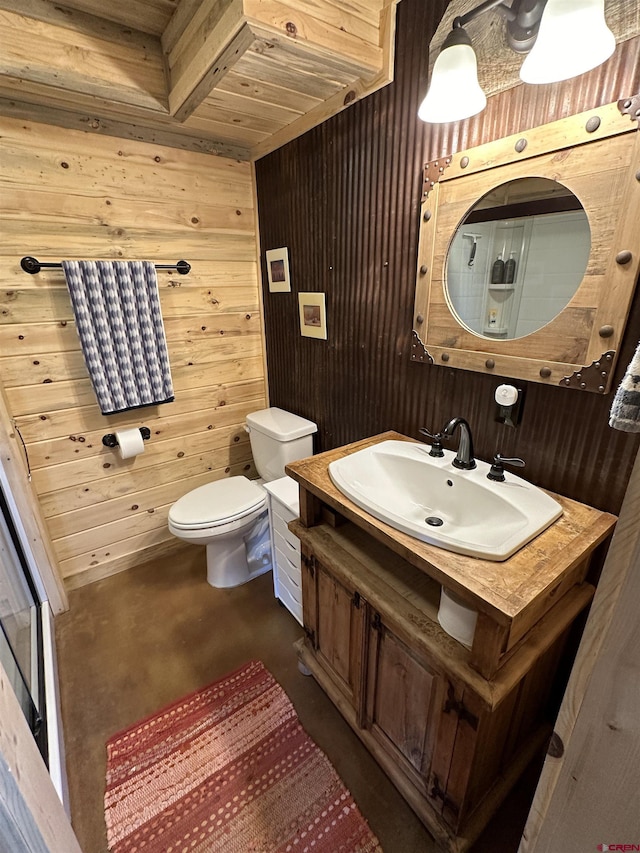 bathroom featuring vanity, toilet, concrete floors, and wood walls