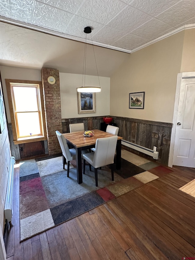 dining space featuring crown molding, dark wood-type flooring, and a baseboard radiator