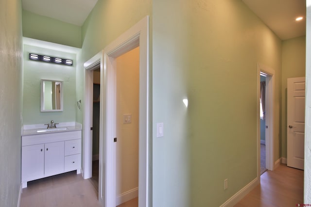 hallway with sink and hardwood / wood-style flooring