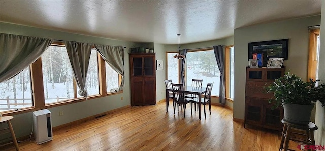 dining room featuring a textured ceiling and light hardwood / wood-style floors