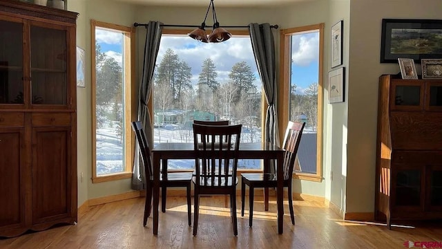 dining area featuring an inviting chandelier and light hardwood / wood-style flooring