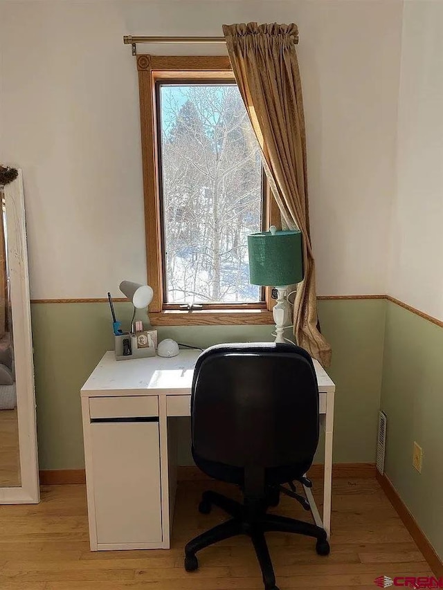 office with plenty of natural light and light hardwood / wood-style flooring