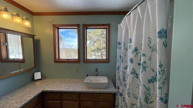 bathroom with plenty of natural light, walk in shower, vanity, and crown molding