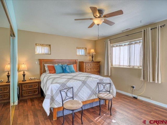 bedroom with a closet, ceiling fan, and dark hardwood / wood-style flooring