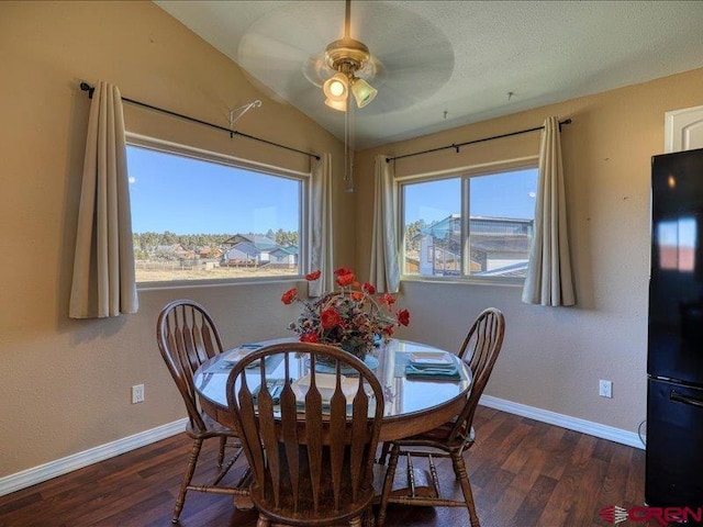 dining space with dark hardwood / wood-style floors, ceiling fan, and vaulted ceiling