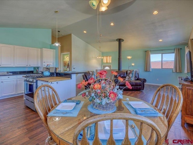 dining space with high vaulted ceiling and dark wood-type flooring