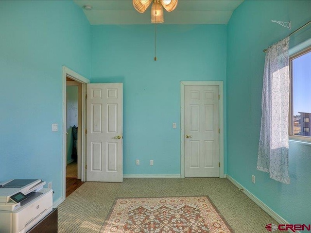 carpeted bedroom featuring a towering ceiling and ceiling fan